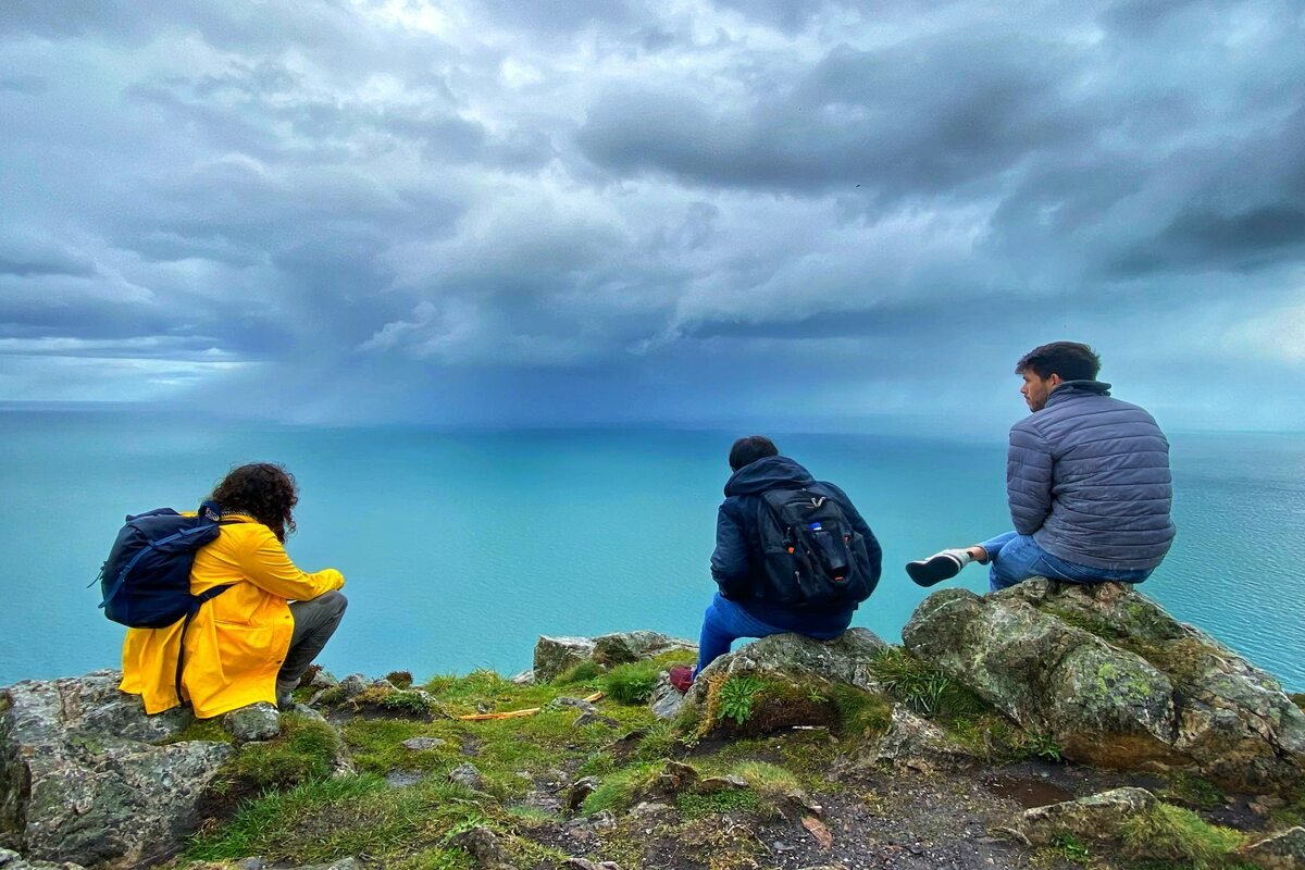 Three people sitting at a beautiful view in Ireland