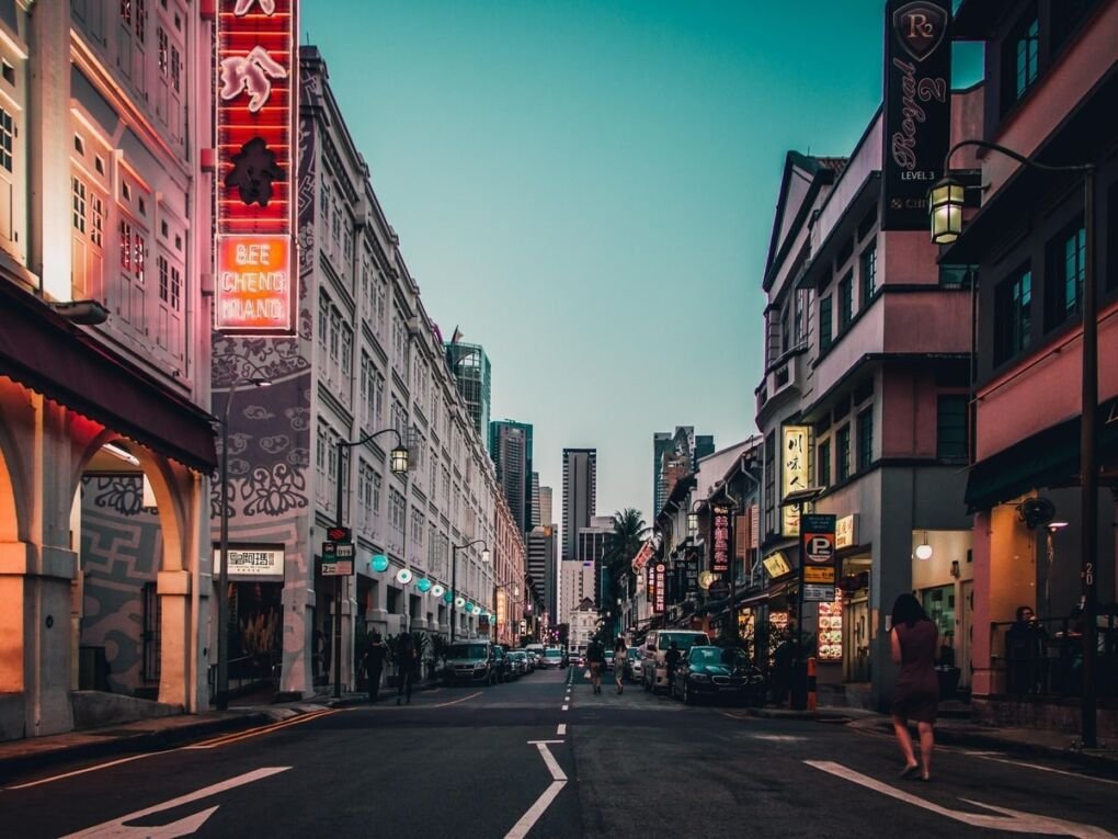 People walking in Singapore's Geylang neighborhood at dusk.