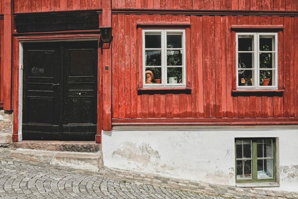 Red house in with closed door and three windows in Oslo City, Norway