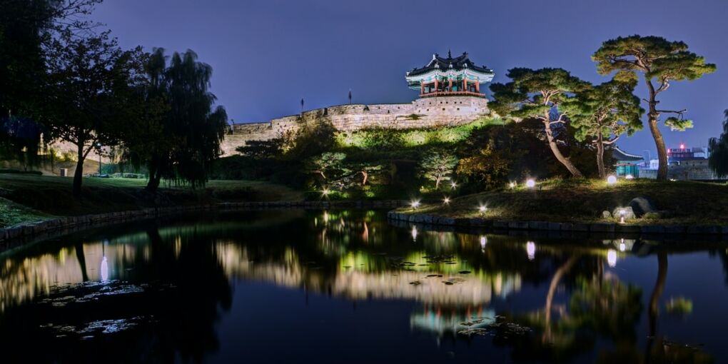 Hwaseong Fortress in with a lake in front of it in Suwon City in South Korea