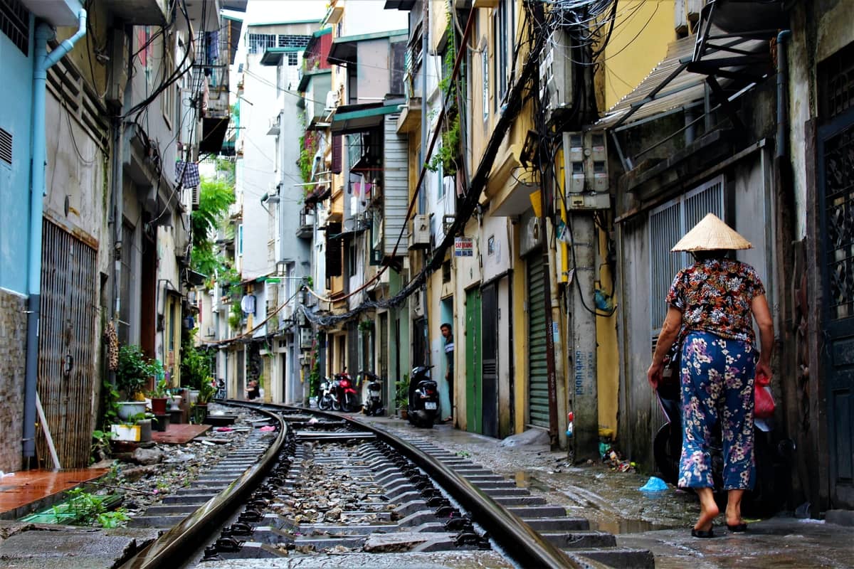 Narrow residential alley where train tracks run through the houses of Hanoi