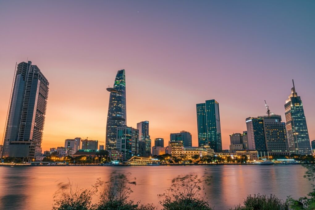 Ho Chi Minh city lit up across the Saigon river during a sunset
