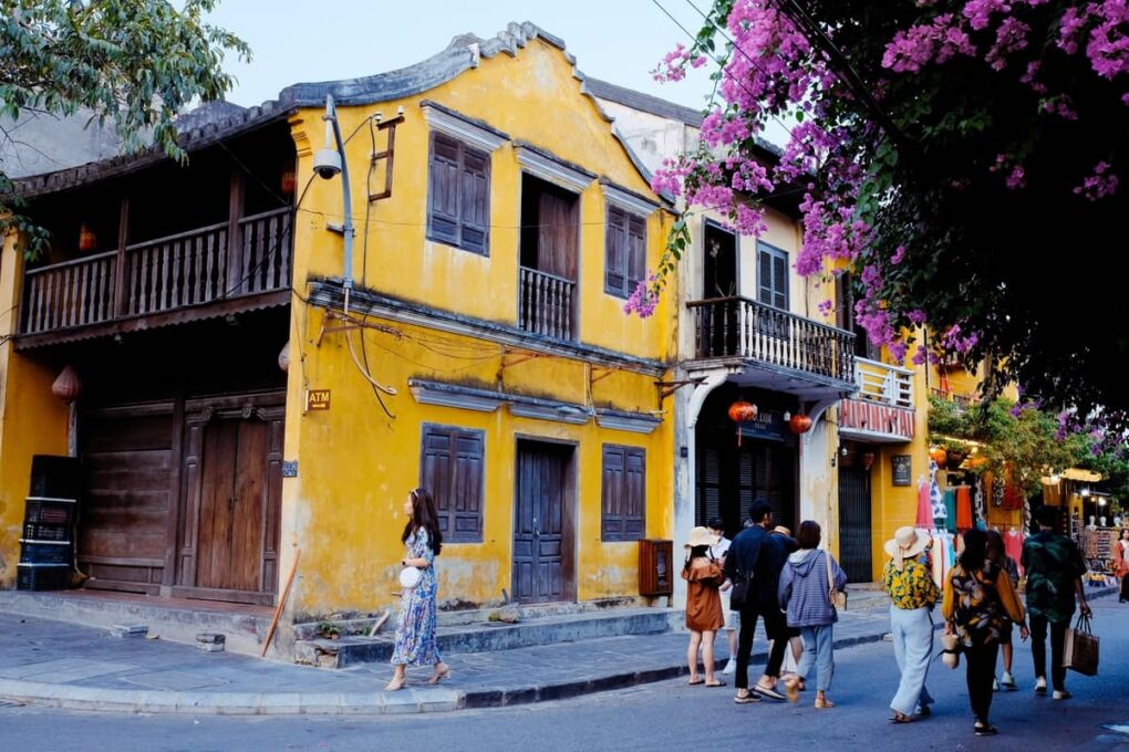 People in front of a yellow building in old town Hoi An in Vietnam