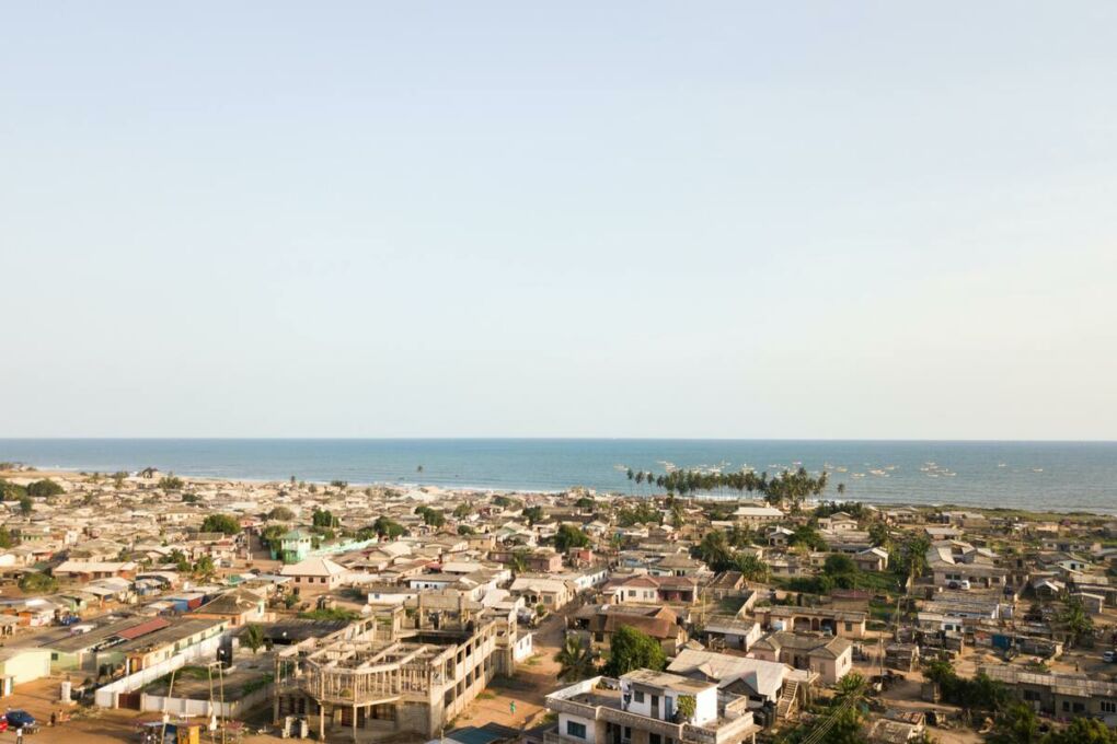 Aerial-shot-overlooking-tropical-town-beside-ocean