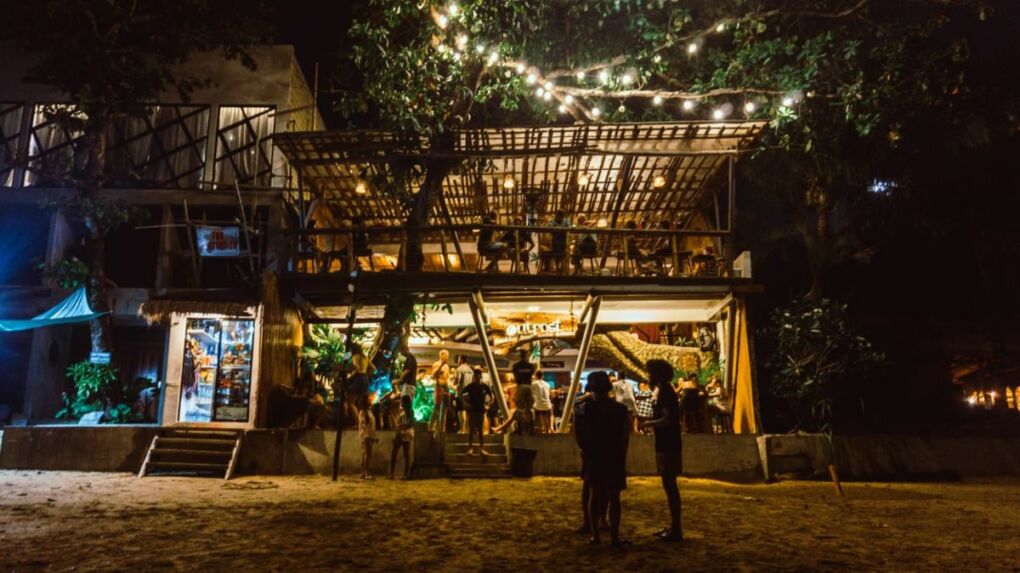 people on the beach outside outpost beach hostel for coliving and coworking in the Philippines