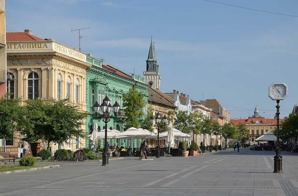 A view of the main street in Sombor with some buildings and a church spire