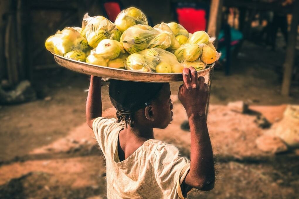 Boy carrying fruit on his head