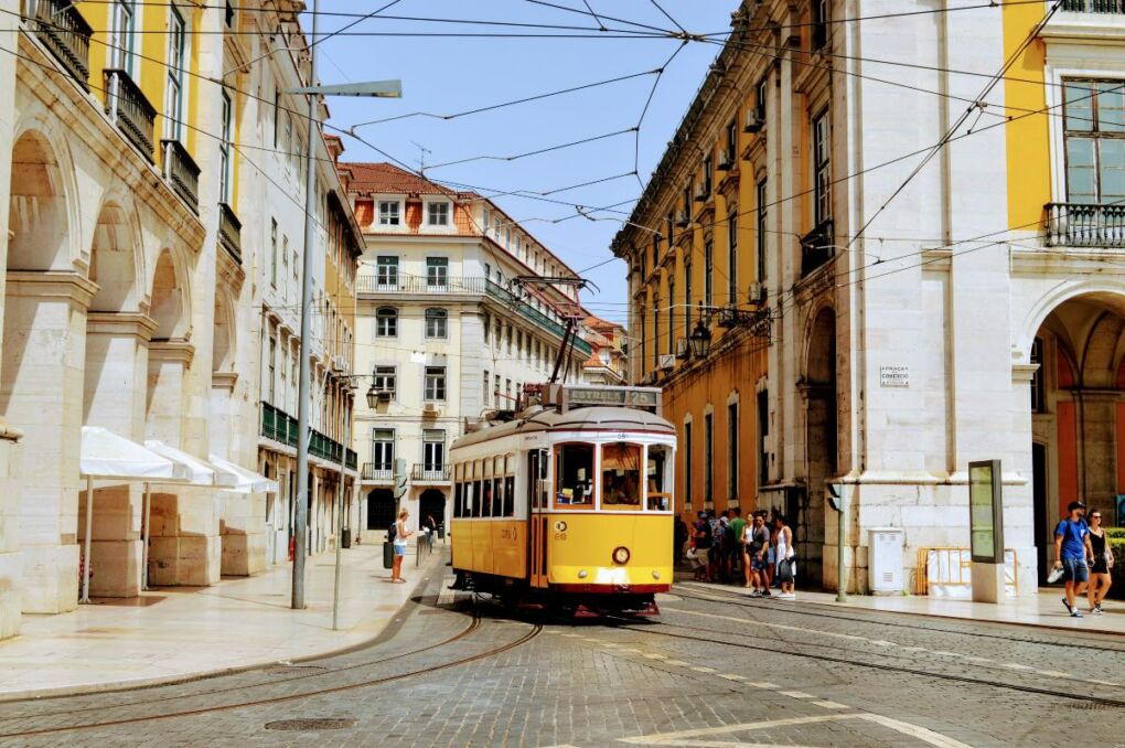 Lisbon's yellow tram going through the city on a sunny day 