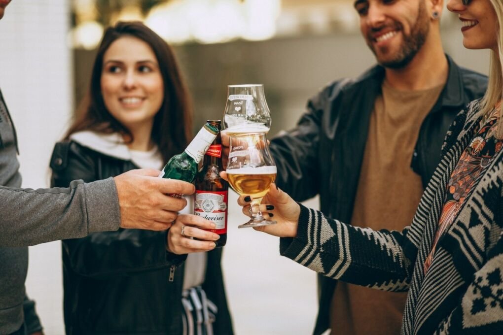 A group of people sharing drinks together and smiling