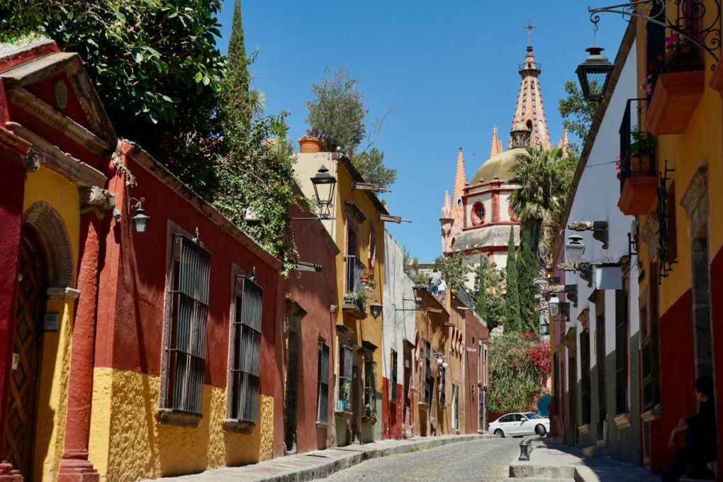 An old, narrow, cobbled street lined with colourful buildings in Mexico. 