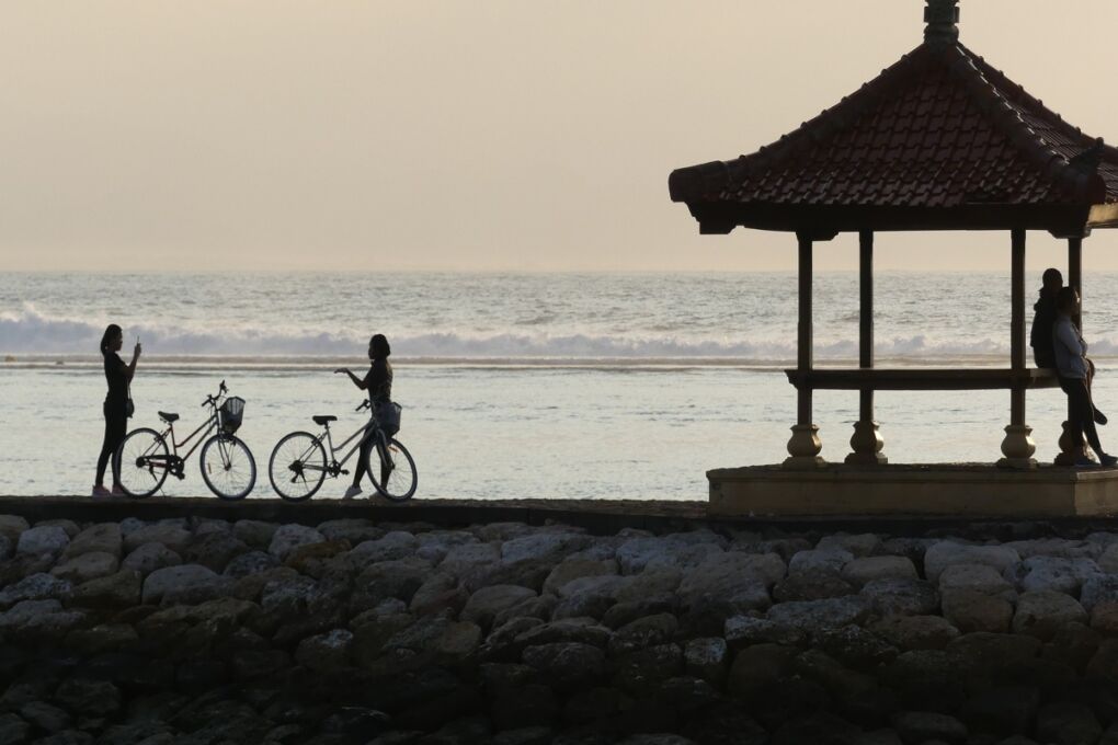 sanur beach sunset people by bicycles
