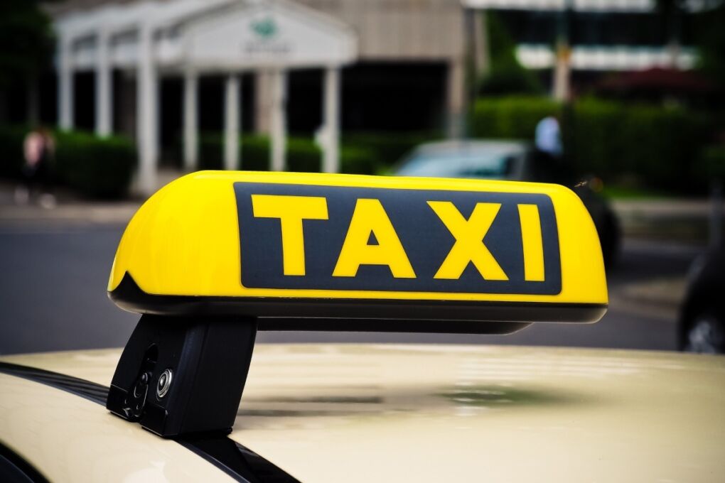 A closeup of a yellow taxi sign on top of a car