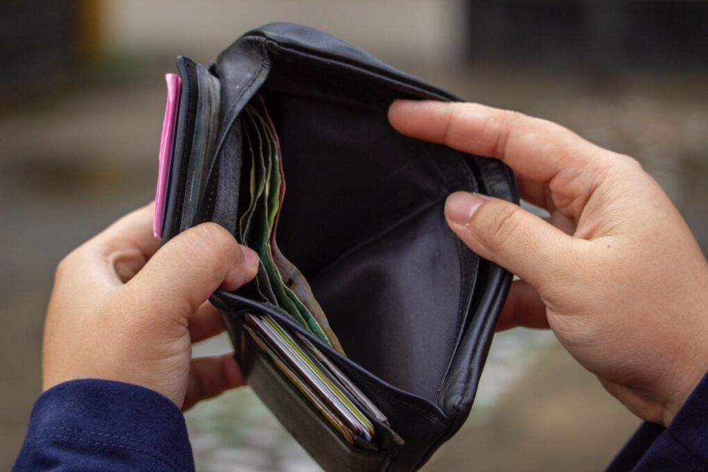Person holding an open wallet with cash inside