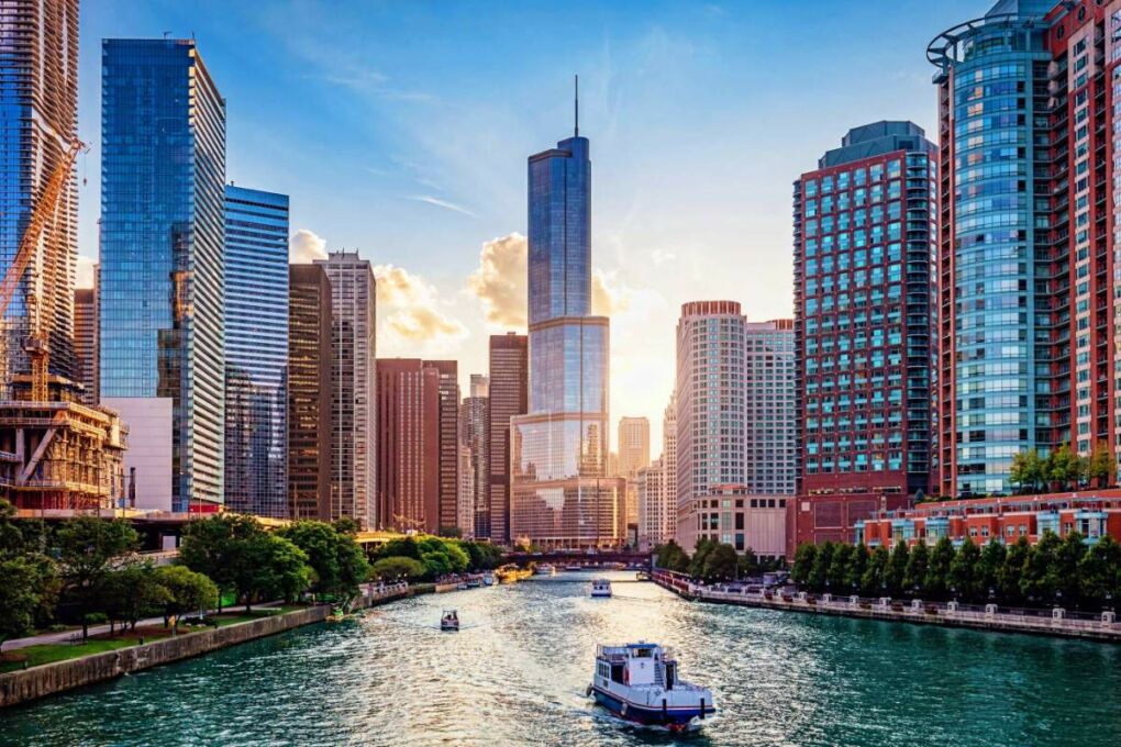 The Chicago River surrounded by buildings at sunset.