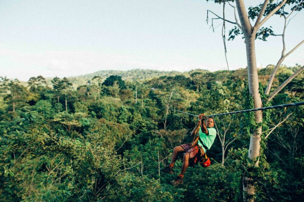 Man ziplining through Costa Rica jungle treetops