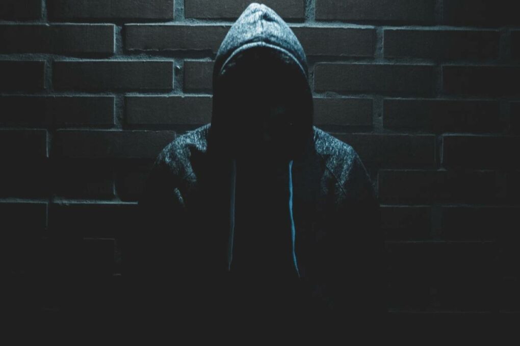 Man Standing Under a light Wearing a Hoody
