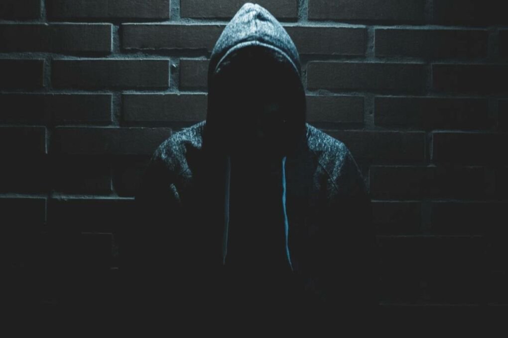 Man Standing Under a light Wearing a Hoody