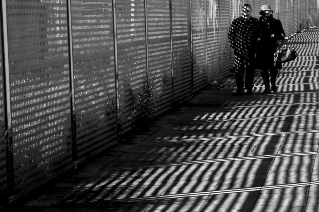 Two people walking together on a path/sidewalk.