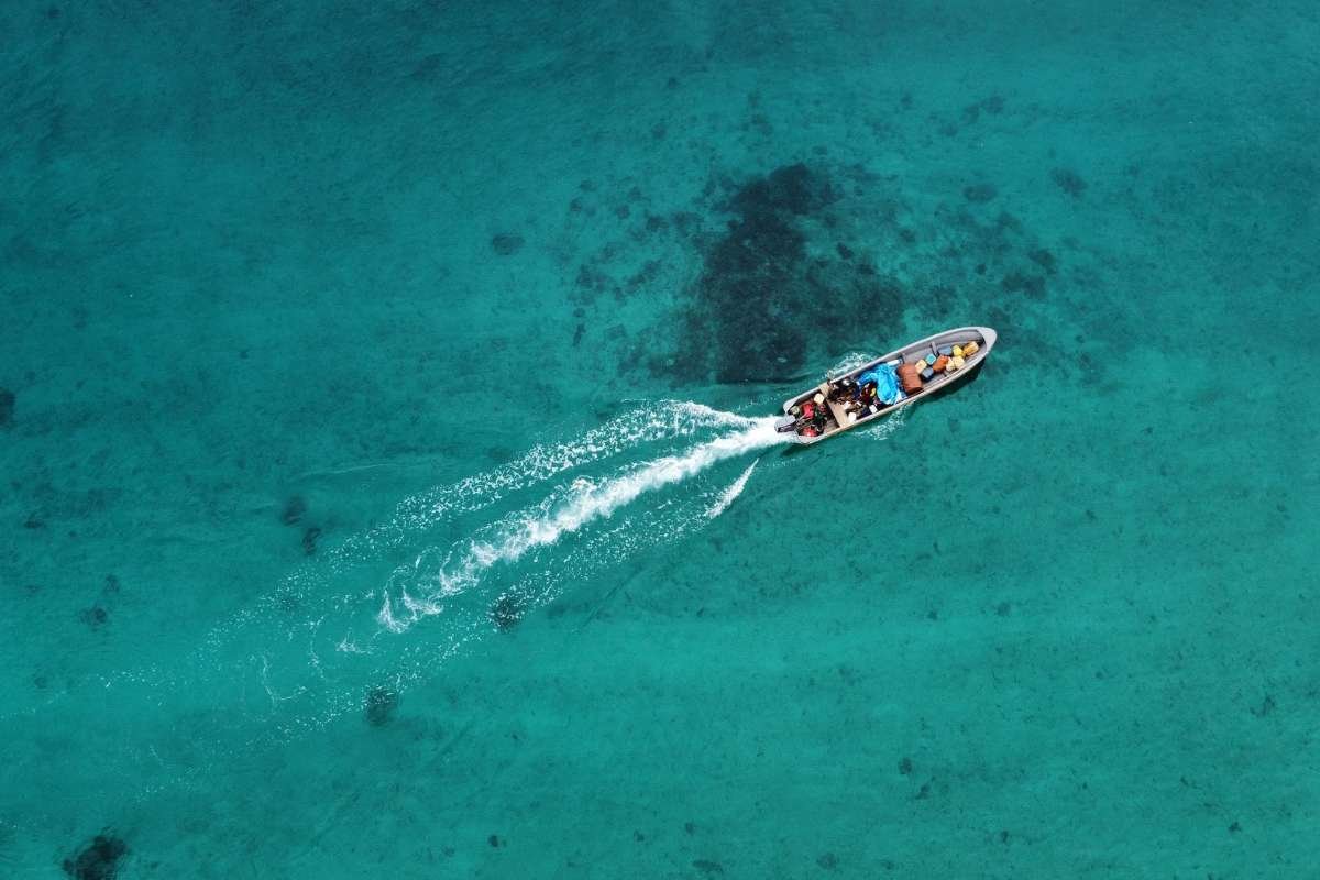 A boat sailing across the blue waters of Milne Bay