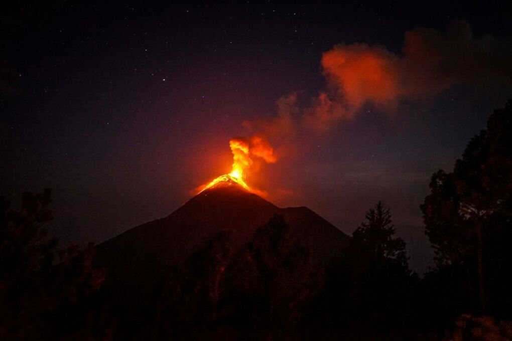 An erupting volcano at night