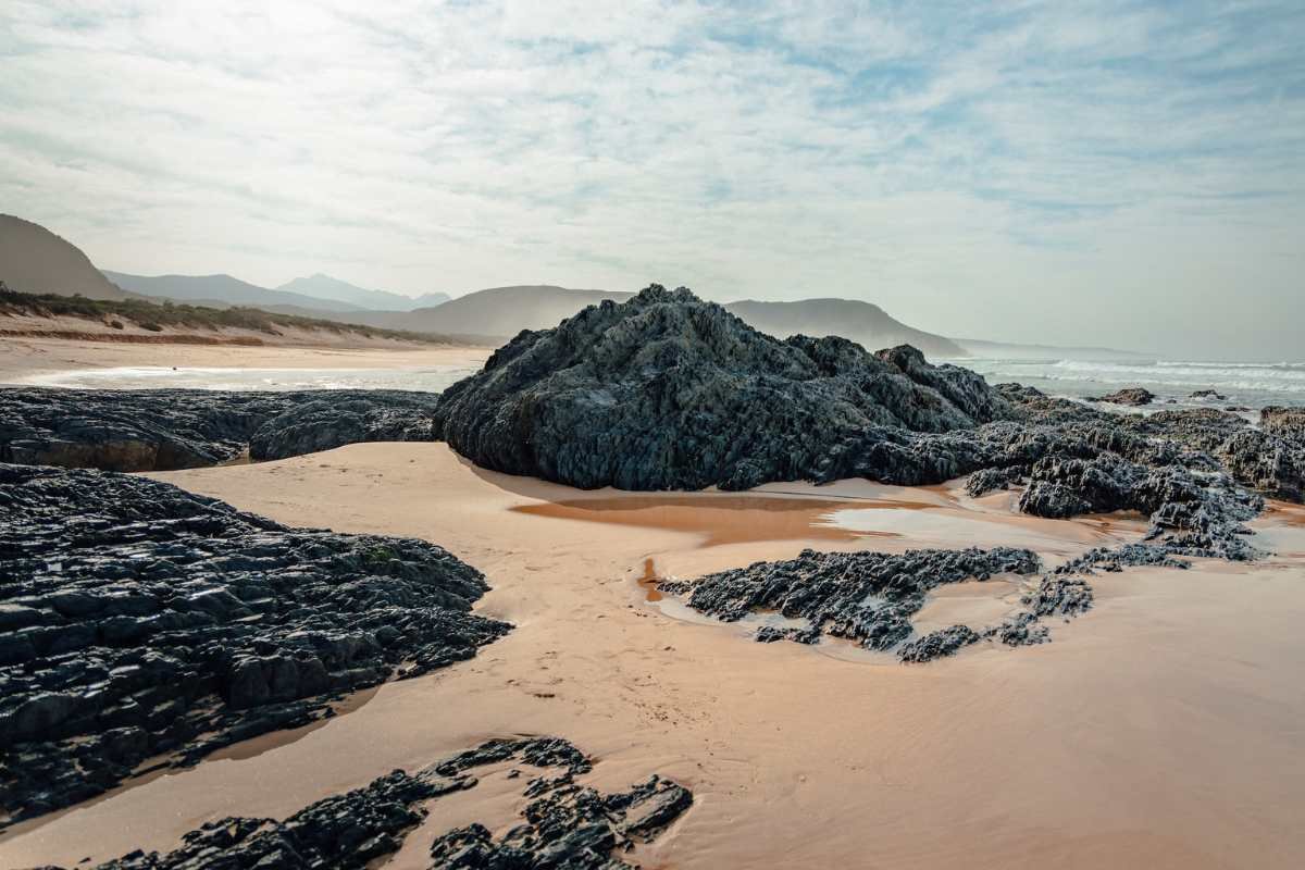 Photo of black rocks on a beach in Nature's Valley