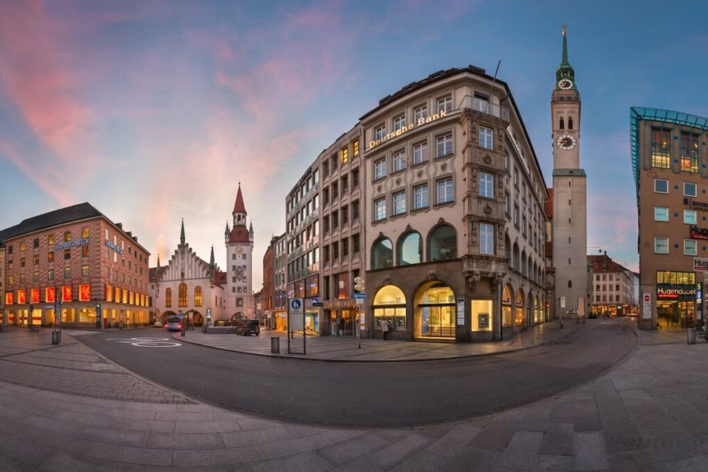 Image of Panorama of Marienplatz in Munich|Two young ladies with luggage checking into a hostel|Wombats worker posing enthusiastically.|Side view image of Wombat's Weksviertel building|Euro Youth Hostel name on glass plaque on wall|Tents from The Tent Hostel on green lawn in Munich|Eating area of YMCA Youth Hostel|Meininger Youth Hostel guests enjoying drinks at the bar.|HI Munich Youth Hostel lobby.||Image of entrance of Smart Stay Hostel Munich City|Image of guests near bunk beds in 4You Hostel|Front view image of Augustin Hostel.|Image of a&o Hostel München Hauptbahnhof Hostel.|Image of a&o München Hackerbrücke Hostel.|Image of a&o München Laim Hostel.|Bedroom in Pandion Boardinghouse.|Image of front of Arthotel Munich.|Security camera.|Granola and dried fruits and nuts on plate.|Cleaner replacing pillowcases.|Two ladies playing pool.|Image of Munich and fall trees lining the streets.|Image of man handing pen to someone to sign a document.|Lady staring pensively at laptop screen.