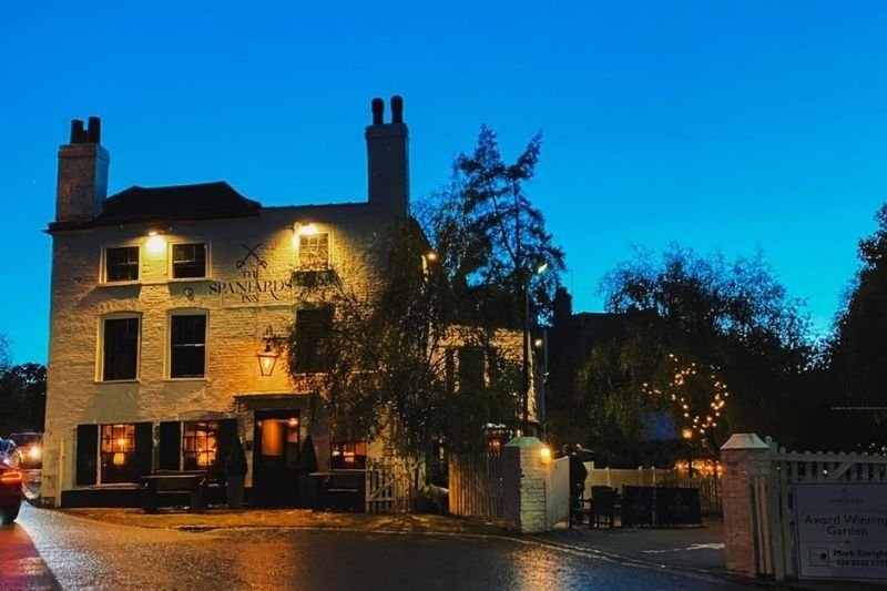 |Ye Olde Cheshire Cheese exterior|Cittie of York pub interior with drinking booths|red exterior of Lamb & Flag pub in London|cat with collar at The Seven Stars pub|Spaniards Inn exterior building view|outside terrace area at George Inn|beers on tap at a London pub