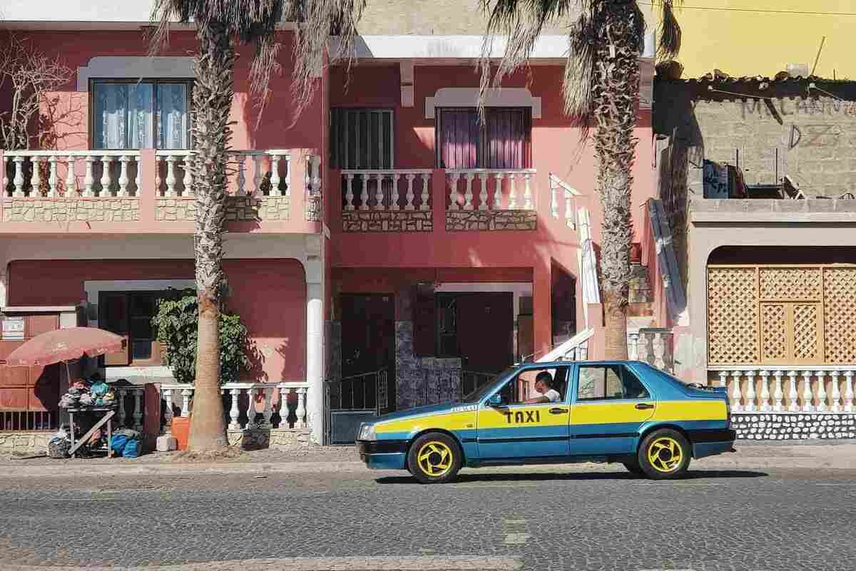 A taxi in front of a pink building in Praia, Cape Verde