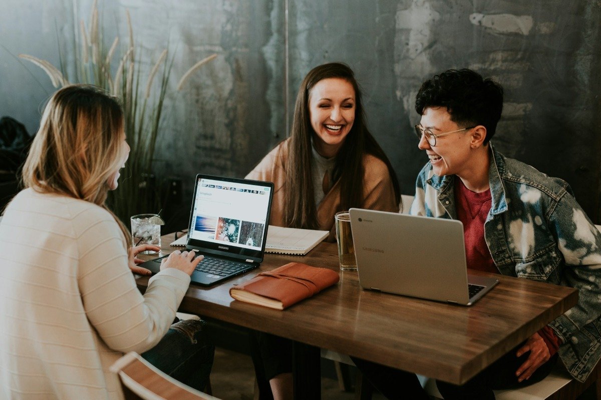 A group of people working on their laptops around a table