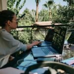 Woman working remotely with her laptop on a table outside