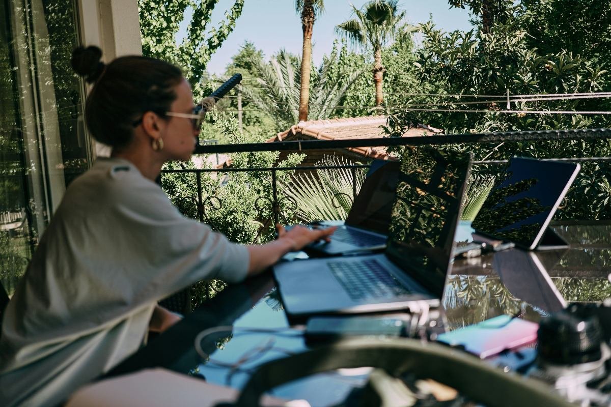 Woman working remotely with her laptop on a table outside